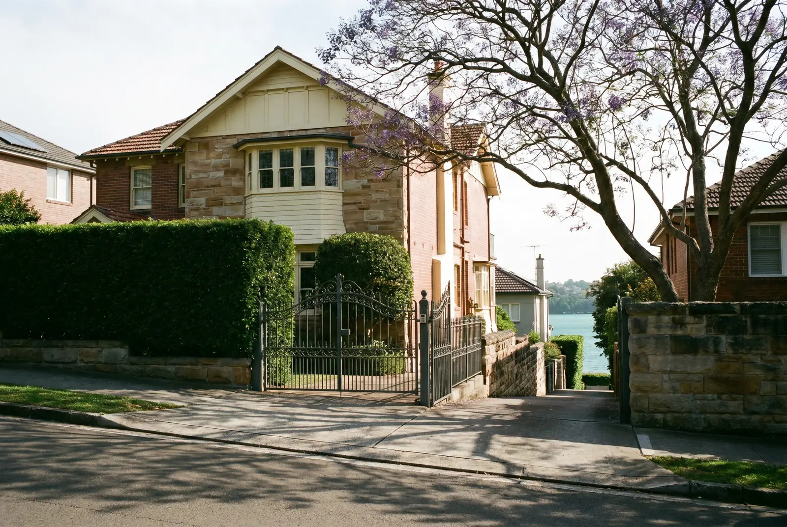 A grand heritage home behind hedges on an elevated Bellevue Hill street